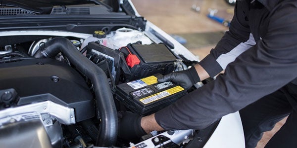 A Buick technician replacing a car battery